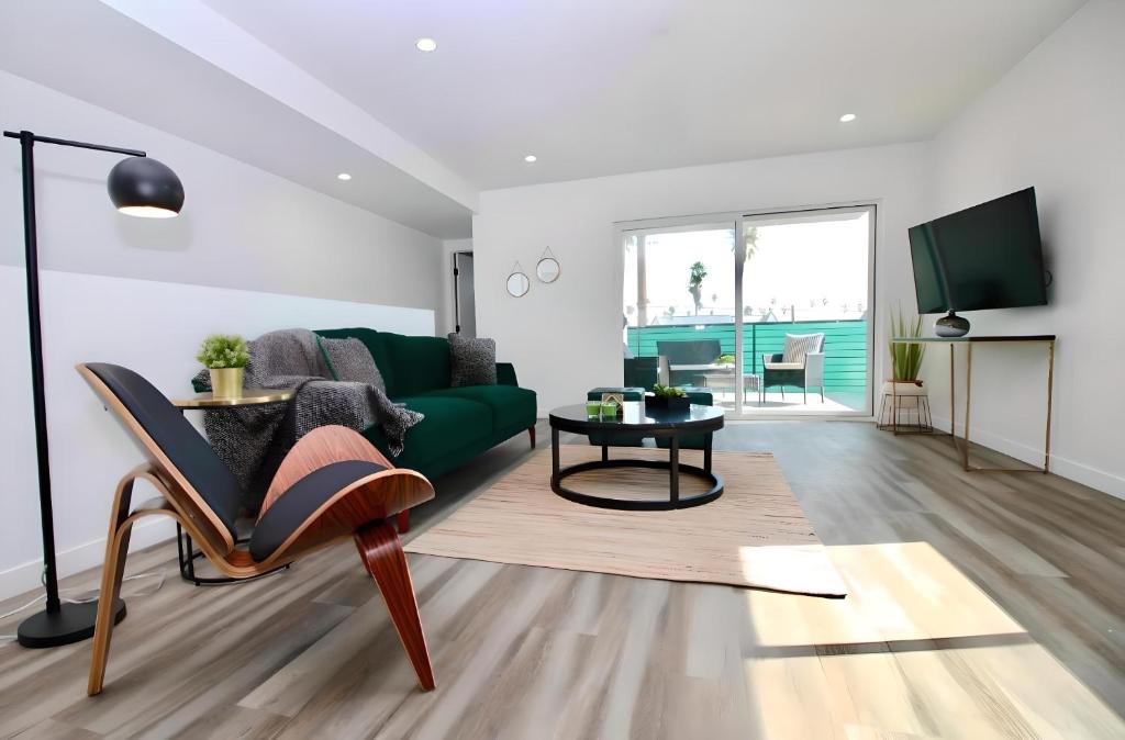 sala de estar con sofá verde y mesa en Los Angeles 3BR Villa Suites with Free Parking, en Los Ángeles