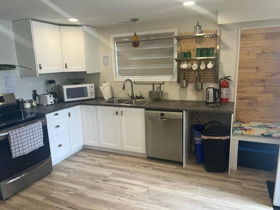 a kitchen with white cabinets and stainless steel appliances at Small lakefront cabin in Sylvan Lake