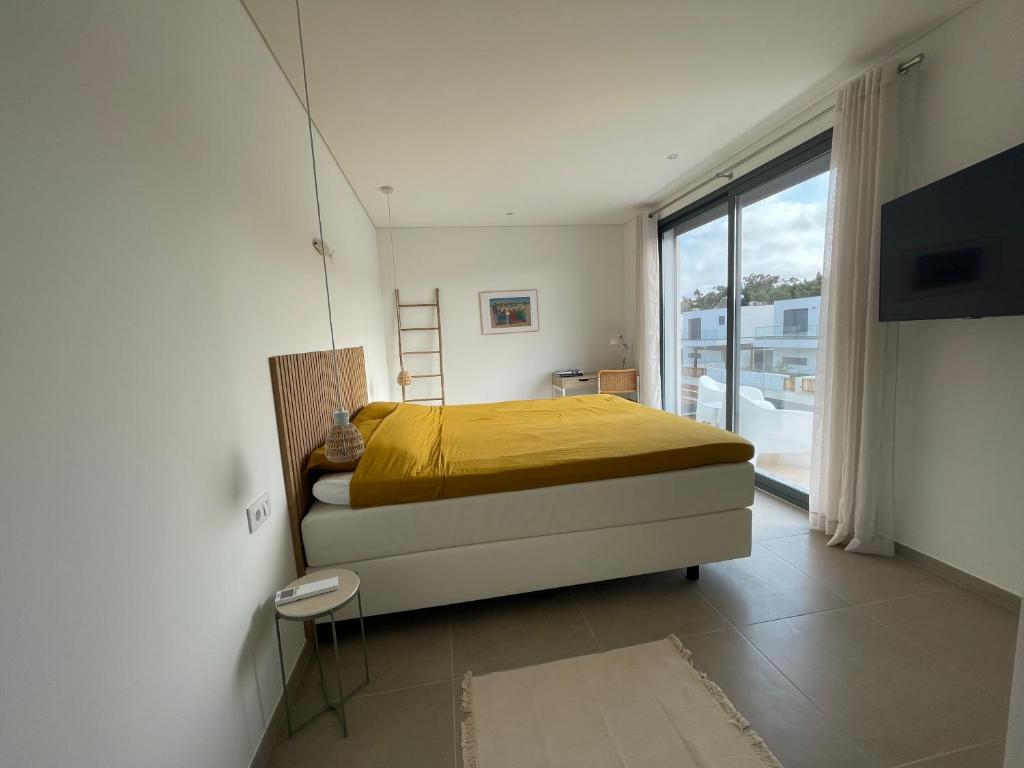 a bedroom with a bed and a large window at Villa Pampelonne in São Martinho do Porto
