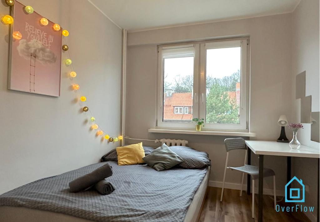 1 dormitorio con cama, escritorio y ventana en Superfly room, en Gdansk