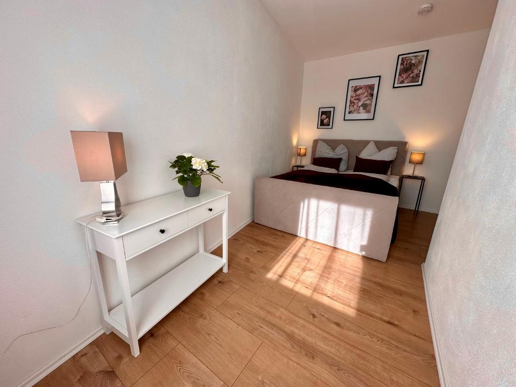 - une chambre avec un lit et une commode blanche avec une table de chevet dans l'établissement Retreat am Teich, à Altenburg