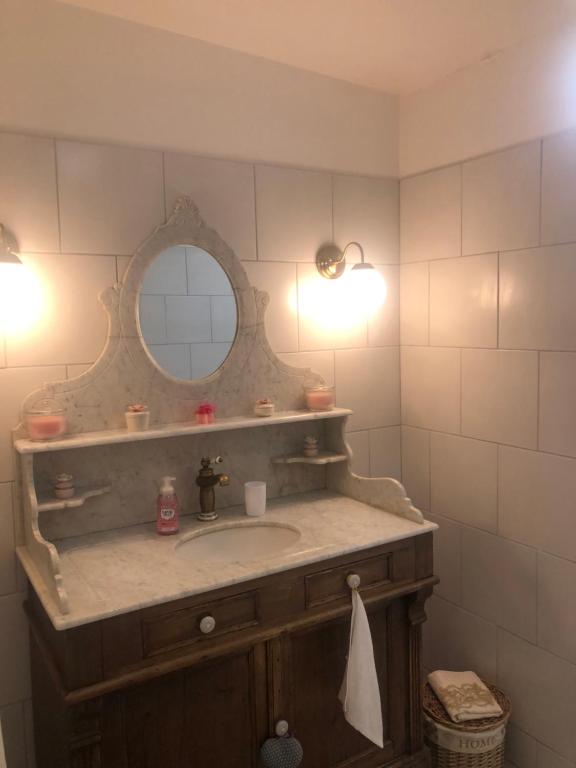 W łazience znajduje się umywalka i lustro. w obiekcie Le choupisson w mieście Estoublon