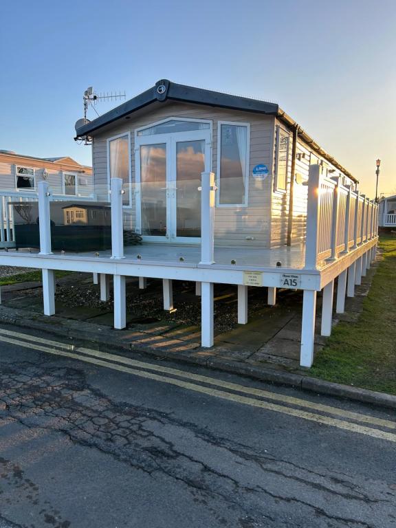 a tiny house on a dock on the side of the road at 3 BEDROOMED CARAVAN WITH AMAZING SEA VIEWS! in Scarborough