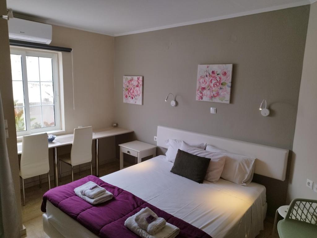 Un dormitorio con una cama con sábanas moradas y una mesa. en Villa Katerina en La Canea