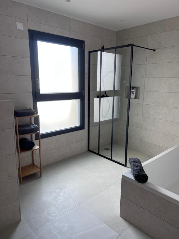 La salle de bains est pourvue d'une douche, d'une baignoire et d'une fenêtre. dans l'établissement Maxime, à Colmar