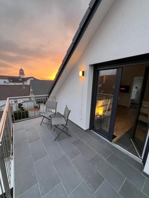 a balcony with a table and chairs on a building at Charmantes Studio-Apartment im Herzen von Neureut - Fußbodenheizung, Regendusche, Waschmaschine, Stellplatz in Karlsruhe