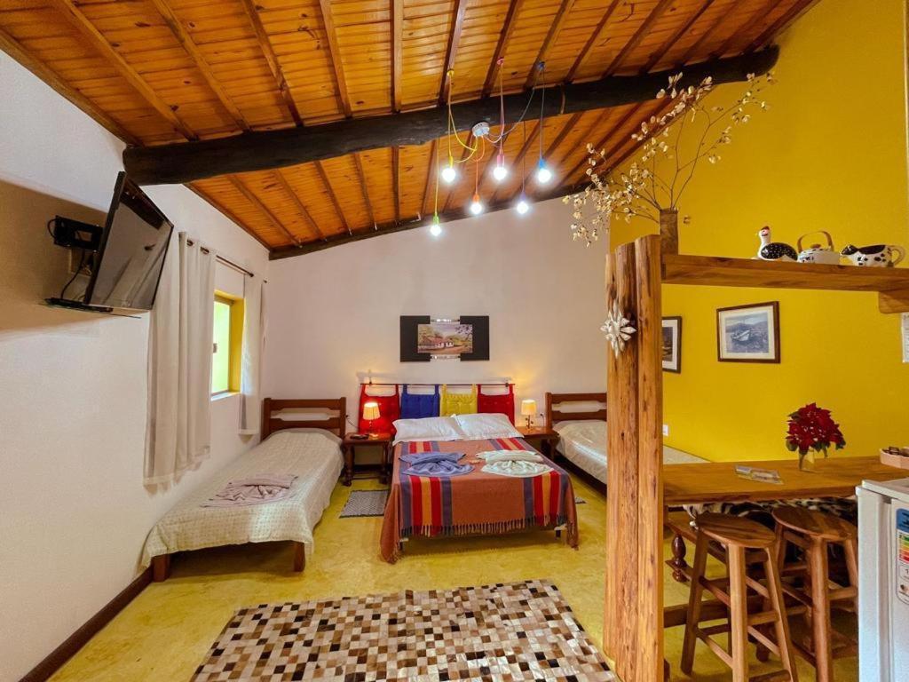 CostasにあるChalés lá na roçaのベッド2台とテーブルが備わる客室です。