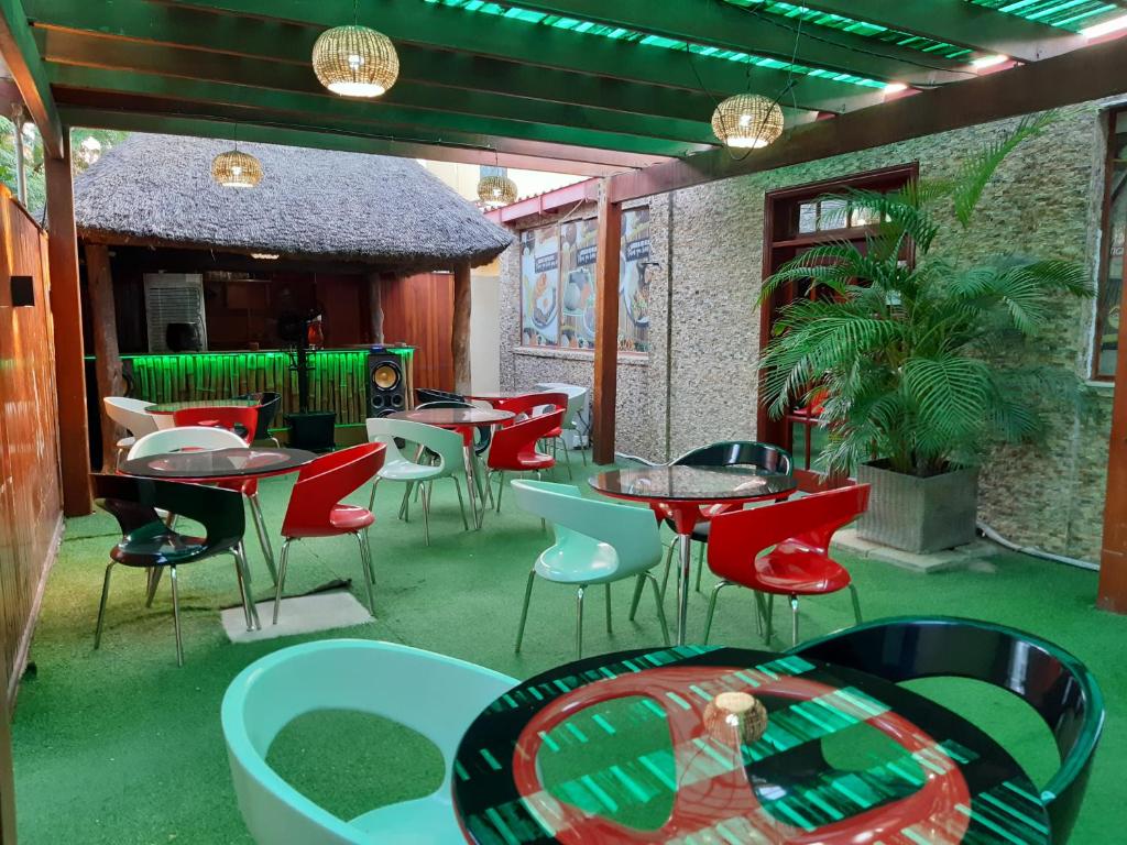een terras met tafels en stoelen in een restaurant bij Hospedaria Restaurante Xeque Mate in Luanda