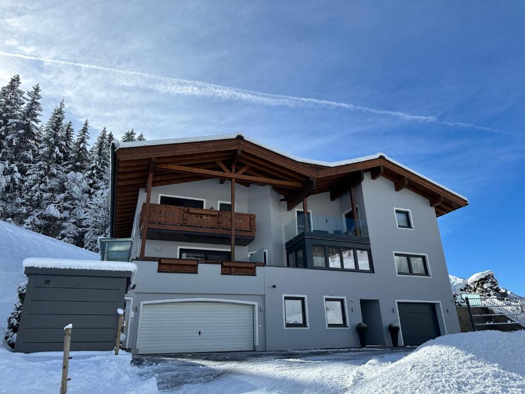 a house in the snow with a roof at Willi's Holidays Home in Saalbach-Hinterglemm