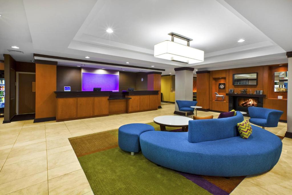 a lobby with a blue couch and chairs and a stage at Fairfield Inn & Suites by Marriott Lexington North in Lexington