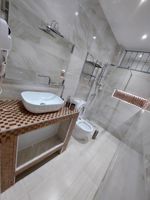 a bathroom with a sink and a shower and a toilet at Piscine privative et prestations haut de gamme in Dakar