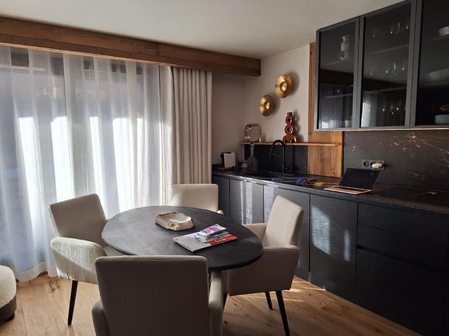 a living room with a table and chairs and a kitchen at paisible appartement près des pistes in La Salle Les Alpes