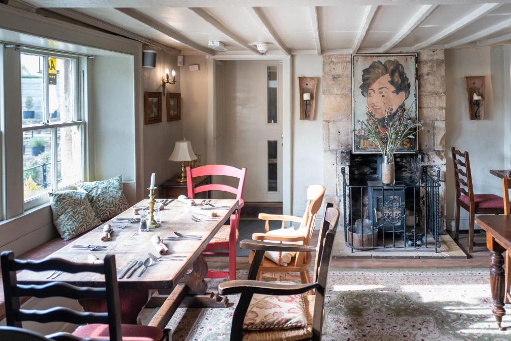 a dining room with a table and chairs and a fireplace at The George in Bradford on Avon