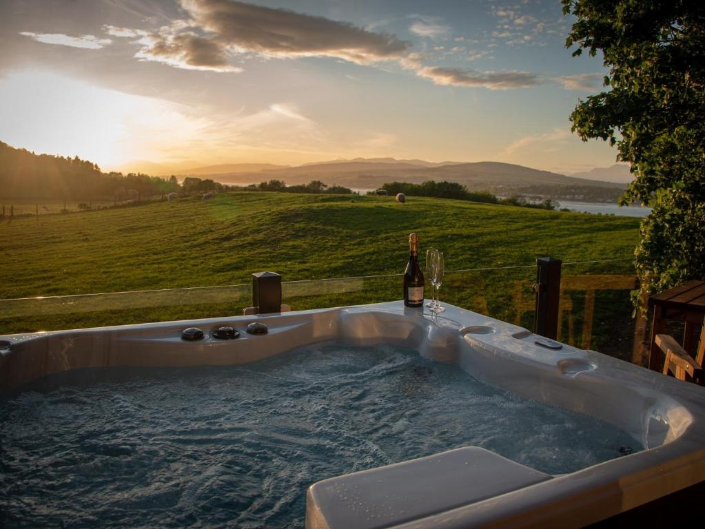 a jacuzzi tub with a bottle of wine at 1 Bed in Langbank 73846 in Langbank