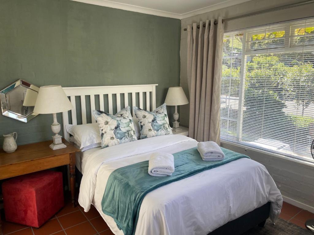 a bedroom with a bed with two towels on it at Joy@Grotto Beach, Hermanus in Hermanus