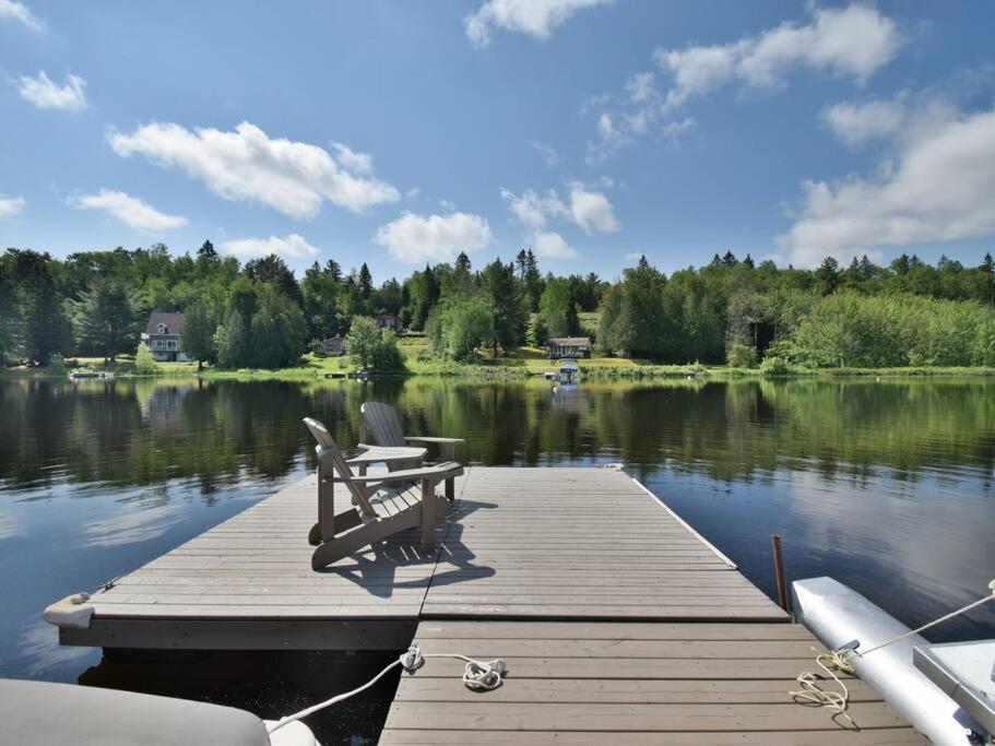 een houten steiger met een bank op een meer bij J&K Lakehouse in Saint-Jean-de-Matha