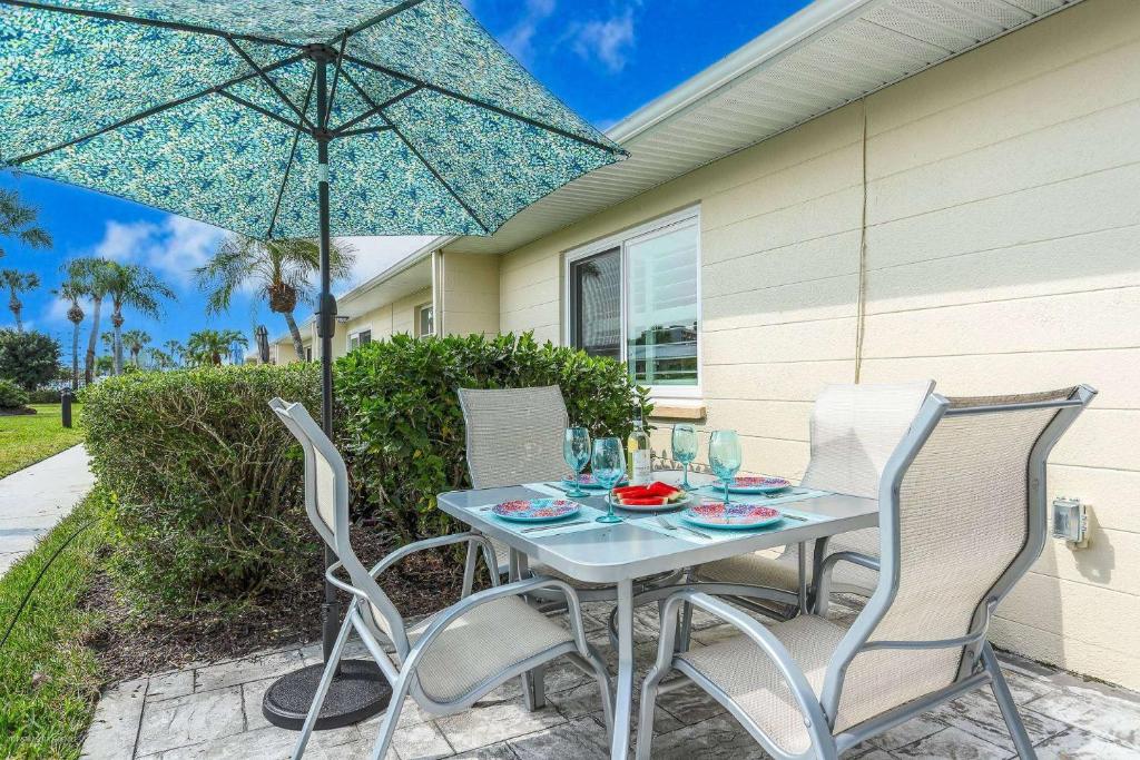 a table with two chairs and an umbrella on a patio at Jamaica Royale Beach Happiness in Siesta Key