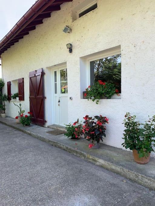 une maison blanche avec des fleurs sur son côté dans l'établissement La Ferme Pouchuc, à Bénesse-Maremne