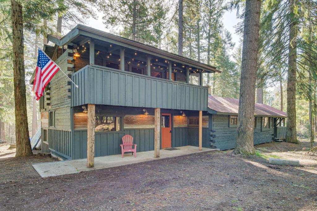 una casa en el bosque con una bandera americana en Klamath Falls Cabin with Private Sauna and Fire Pit! en Klamath Falls
