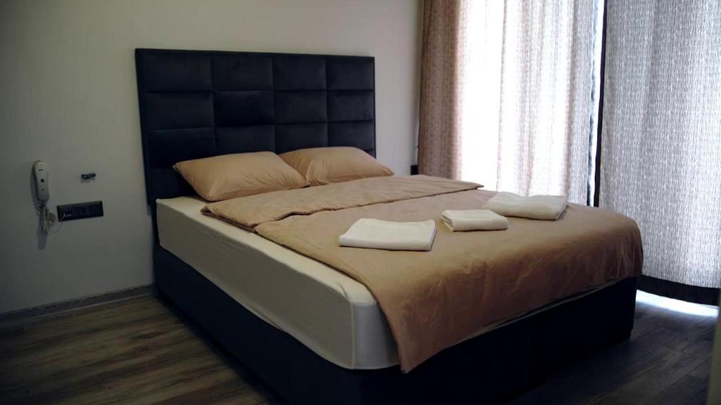 um quarto com uma cama grande com duas toalhas em DEMİR OTEL em Burunabat