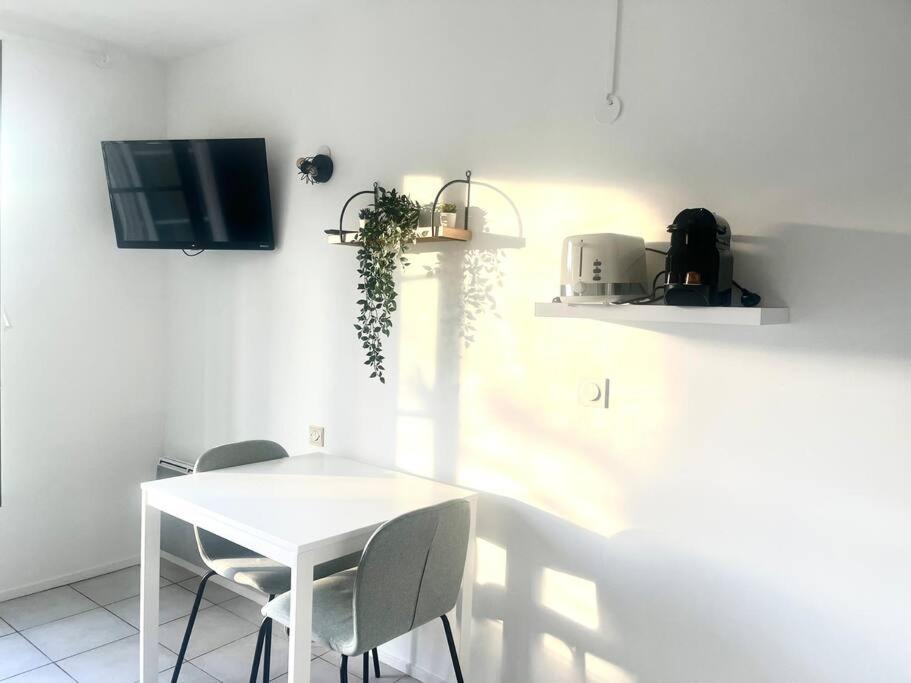 a white dining room with a white table and chairs at Studio - 4 pers. 10min Disney in Bussy-Saint-Georges