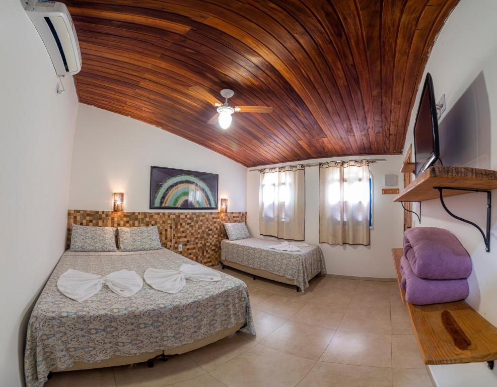 um quarto com uma cama grande e um tecto de madeira em Pousada Nativos Lençois em Lençóis
