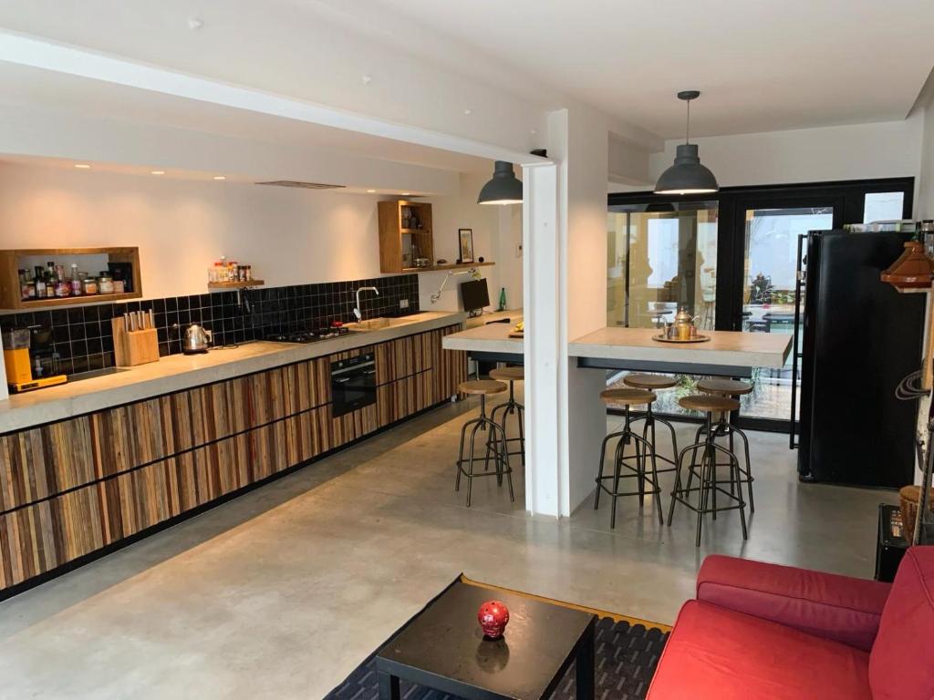 uma cozinha e sala de estar com um sofá vermelho em Dunes de Blankenberge - Luxurious Open Loft apartment em Blankenberge