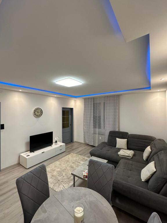 a living room with a couch and a tv at Familien Apartment in Niederaigen