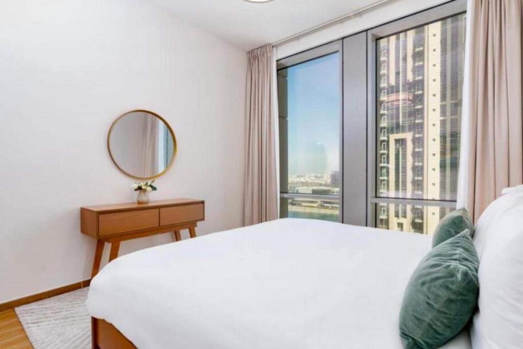 a bedroom with a white bed and a large window at Apartament Great view Dubai in Dubai