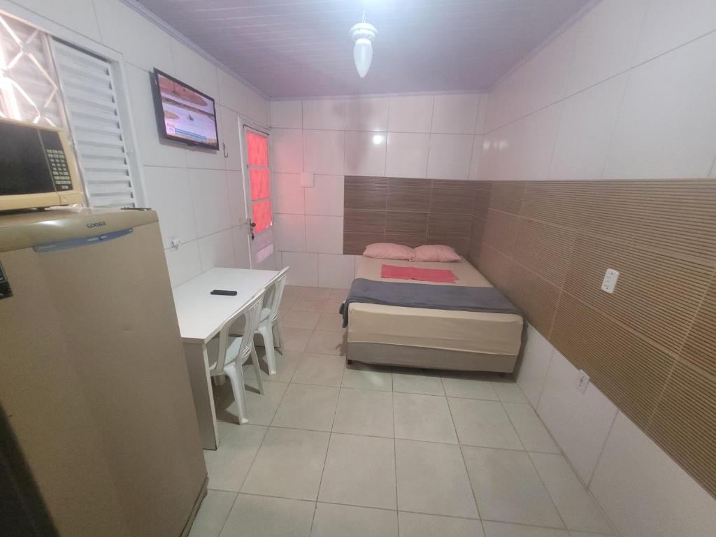 a small room with a bed and a desk at 01 arniqueira df simples in Brasilia