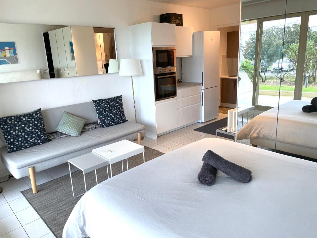 Habitación con cama, sofá y cocina. en ღ La Corniche • Grand Studio, Piscine & Parking, en La Rochelle