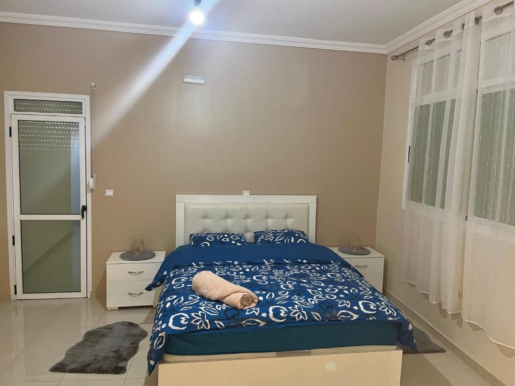 a bedroom with a bed with a blue comforter at Maison vue mer Al Hoceïma in Al Hoceïma