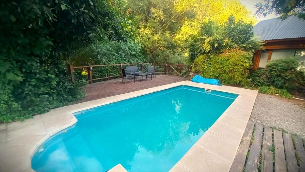 - une piscine dans une cour avec un banc dans l'établissement Refugio del Arroyo, à San Martín de los Andes
