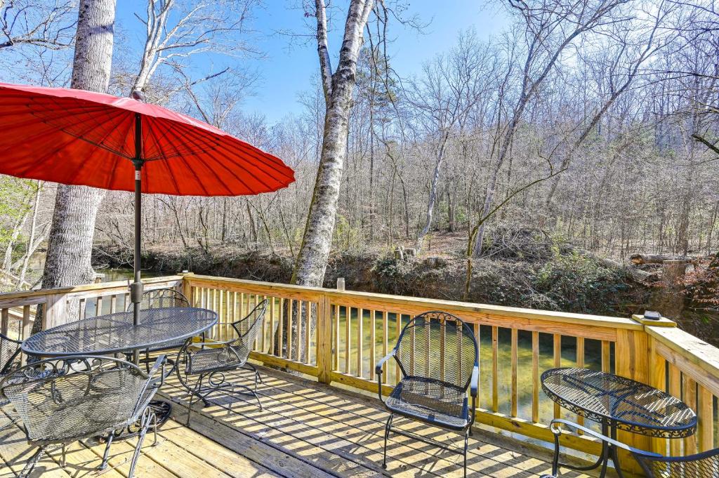 una terraza con mesa, sillas y sombrilla en Cleveland Home with South Saluda Fishing Access, en Cleveland