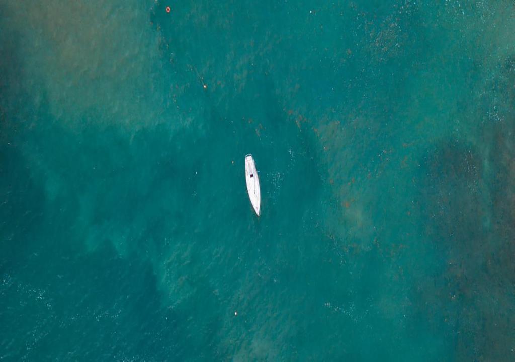 a white boat in the water in the ocean at Hotel Bahía Aguacate in Capurganá