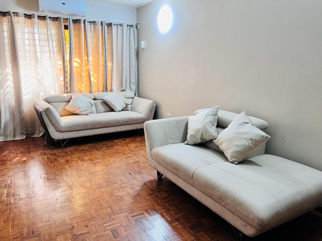 a living room with two couches in front of a window at Casa para Férias in Inhambane