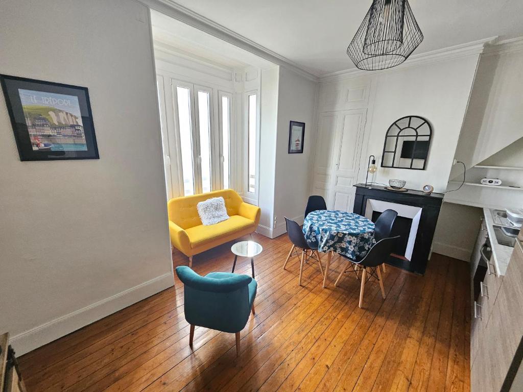 ein Wohnzimmer mit einem gelben Stuhl und einem Tisch in der Unterkunft Entre 2 flots 2 in Le Tréport
