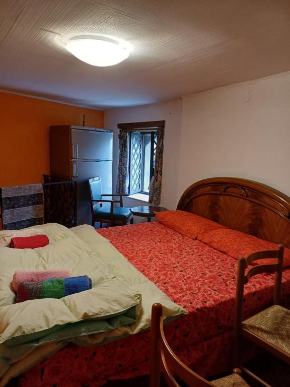 a bedroom with a bed and a table and a refrigerator at Etnalcantara in Castiglione di Sicilia