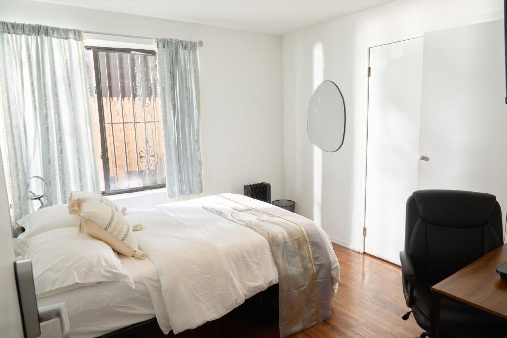 um quarto com uma cama, uma cadeira e uma janela em American Dream Guest House em Nova Iorque