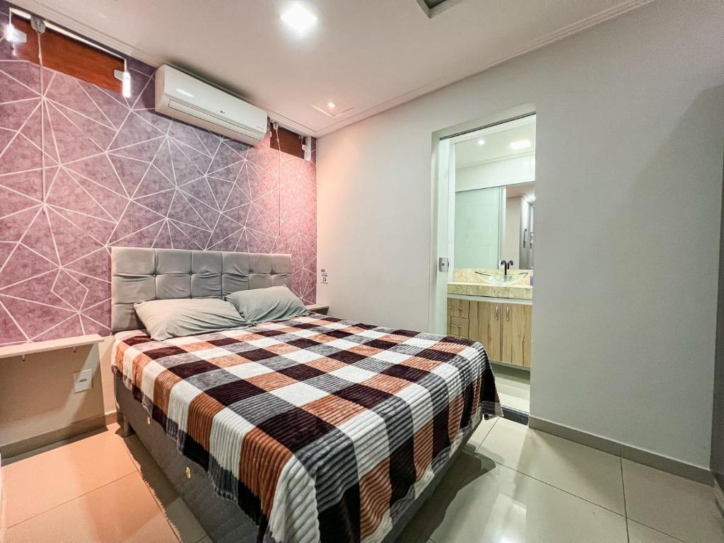 ein kleines Schlafzimmer mit einem Bett und einem Badezimmer in der Unterkunft Apartamento Térreo Charmoso in Cabo Frio