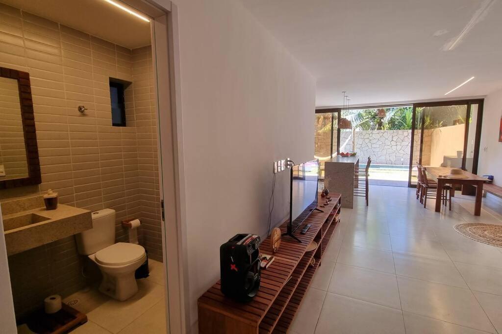 ein Bad mit einem WC und einen Flur mit einem Tisch in der Unterkunft Kanui VK 102 Milagres - Duplex Perto da Capela e Raizeiros in São Miguel dos Milagres