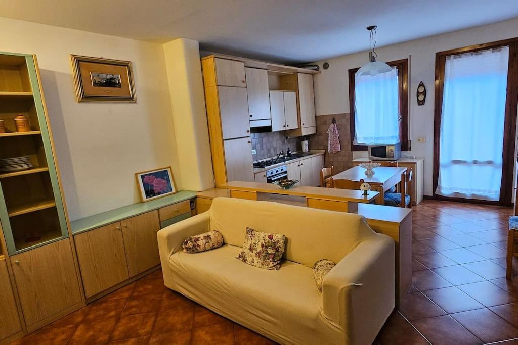 a living room with a couch and a kitchen at Appartamento Elen in Castelfranco Veneto