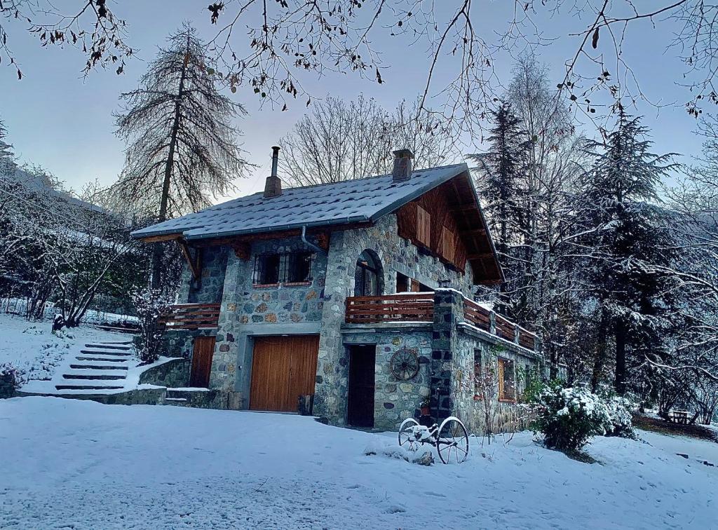 una casa de piedra con un garaje en la nieve en Chalet Le Tilleul, en Valdeblore