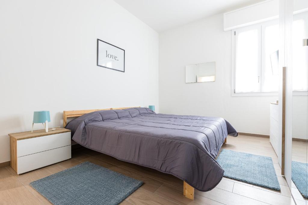 um quarto branco com uma cama e uma janela em Molinari House Modena Rubino em Modena