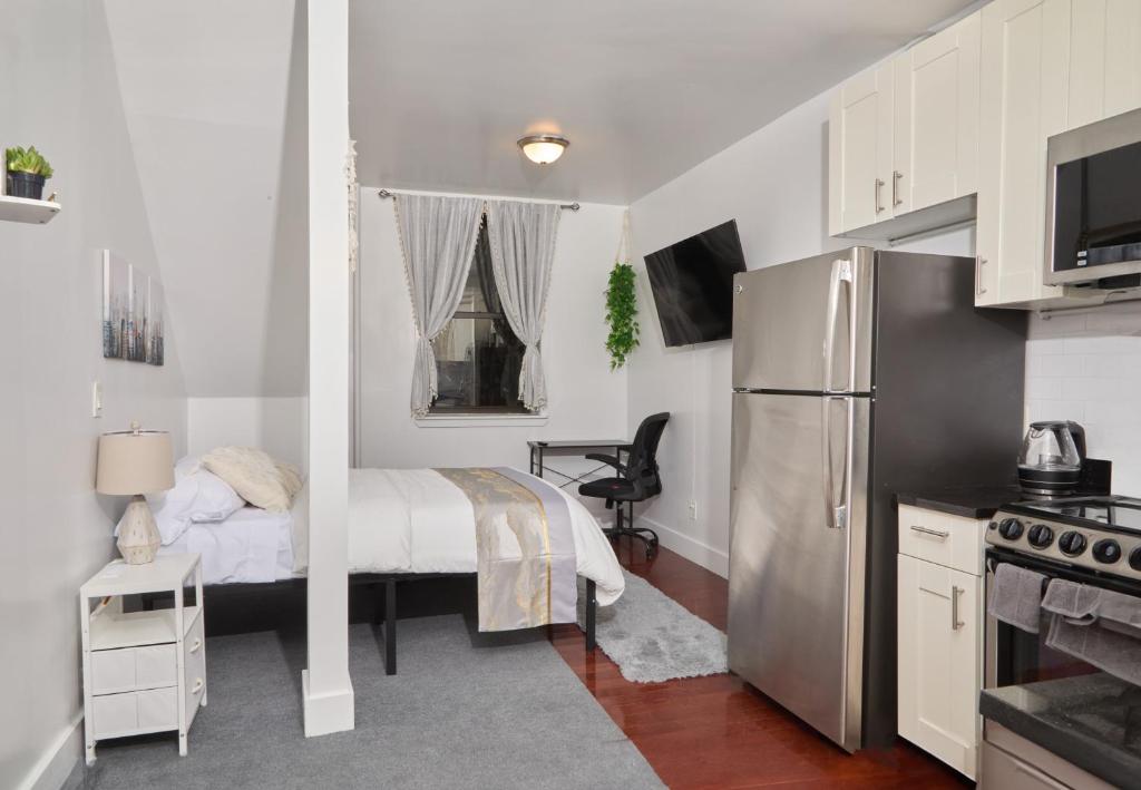 a small bedroom with a bed and a refrigerator at Private Loft in Hells Kitchen near Times Square in New York