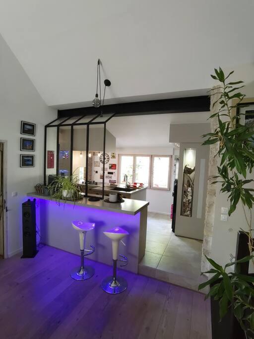 - une cuisine avec tabourets de bar violet dans une pièce dans l'établissement Maison familiale : charme & nature, à Senlis