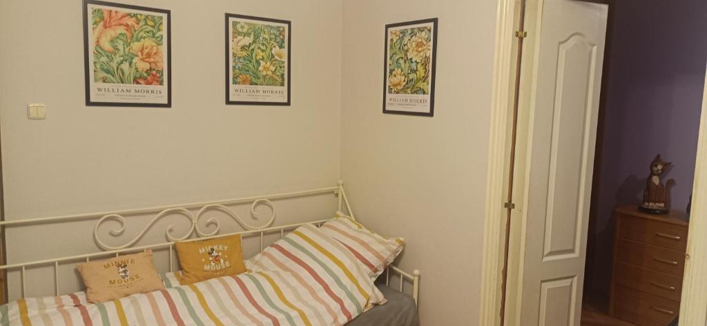 a bedroom with a bed with pillows and pictures on the wall at Apartament VvGogh 4 pokoje in Rzeszów