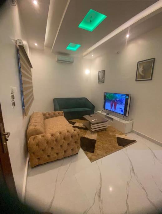 a living room with a couch and a computer monitor at Appartement meublé deux pièces in Agblangandan