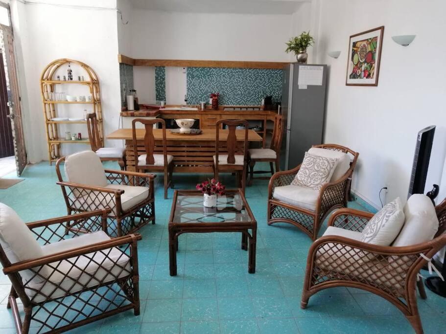 Los Huacales Apartamento في مدينة أواكساكا: غرفة معيشة مليئة بالكراسي وطاولة