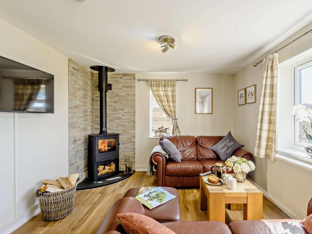 a living room with a couch and a wood stove at 2 Bed in Rhosneigr 81515 in Caeʼr-geiliog